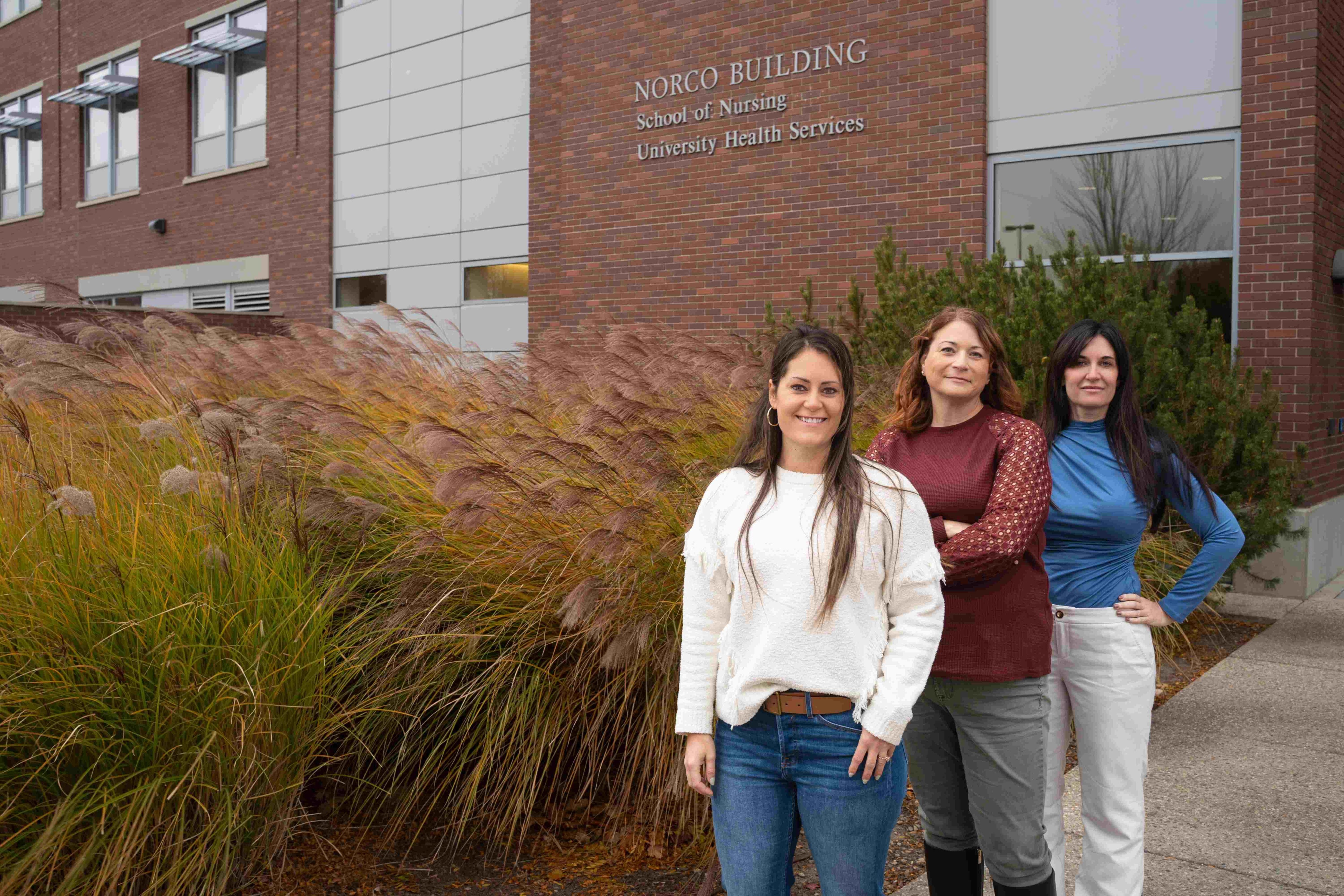 Three persons pose in from of the Boise State NORCO Building