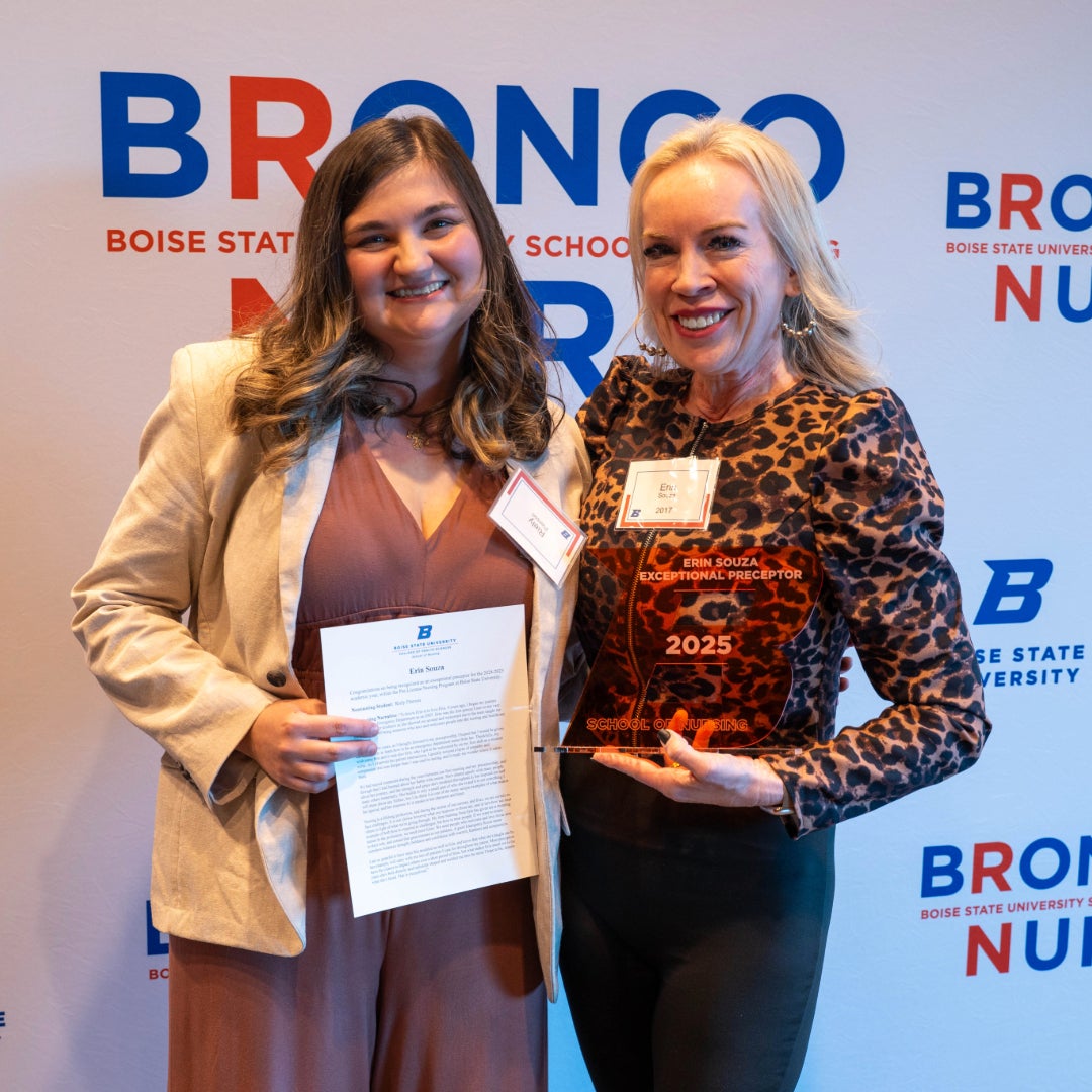 Two persons pose with awards