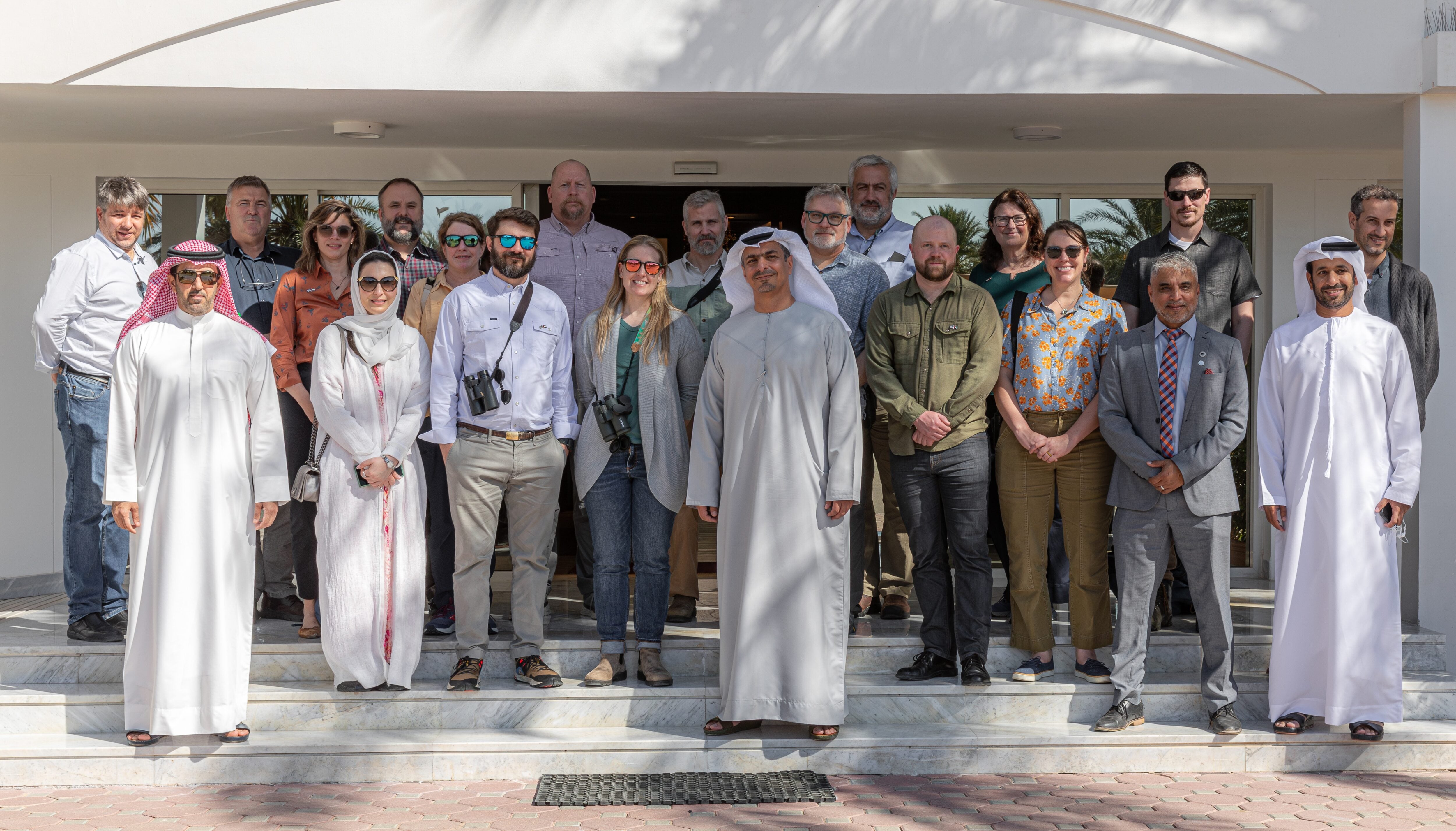 A group of scientists pose for a picture outside of a building.