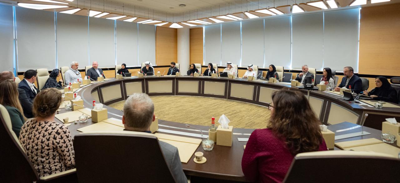 Scientists meet in a room, circled up and discussing. 