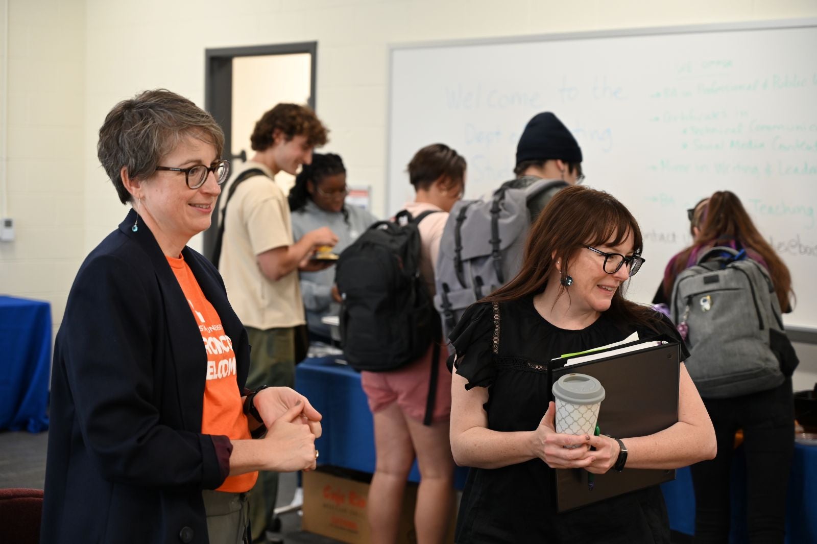 Boise State writing studies faculty converse at a student event