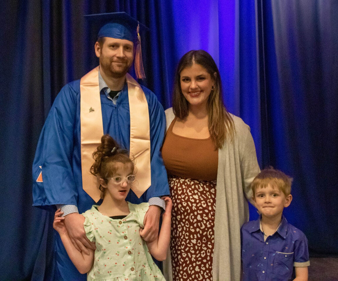 Layne Anderson in regalia with wife and kids