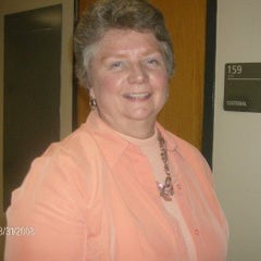 Nancy Otterness stands in the school's hallway and smiles.