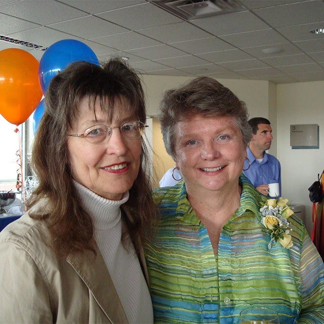 Nancy Otterness smiles with a friend at her retirement party.