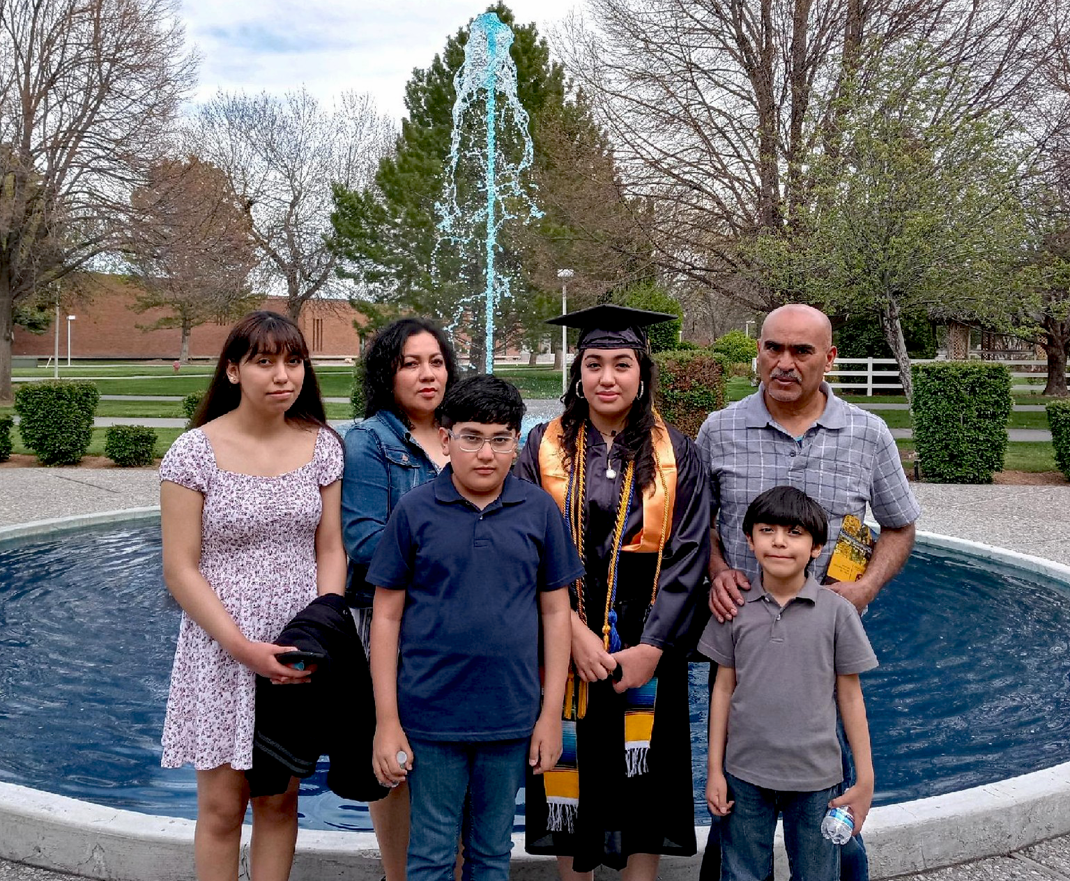 Adilene Ambriz and her family in front of a fountain. 
