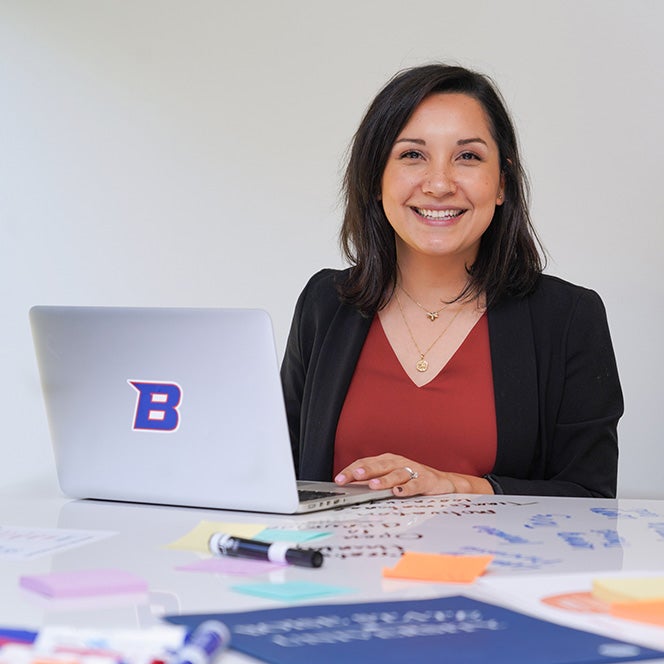 Female student sitting with a laptop smiling