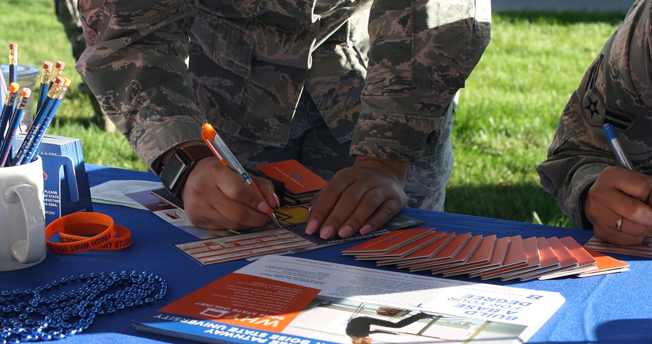 AU-ABC online degree student writing on a Boise State flyer