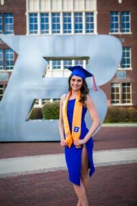 Kayla Romano graduation photo in front of Boise State B on campus 