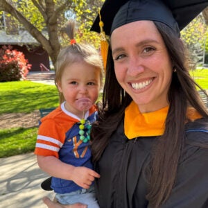 Megan Renaldo in her cap and gown with her baby