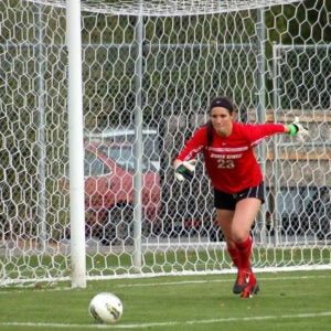 Megan Renaldo on the field, kicking a soccer ball