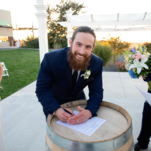 Tyler Dibble leans over a table while wearing a suit