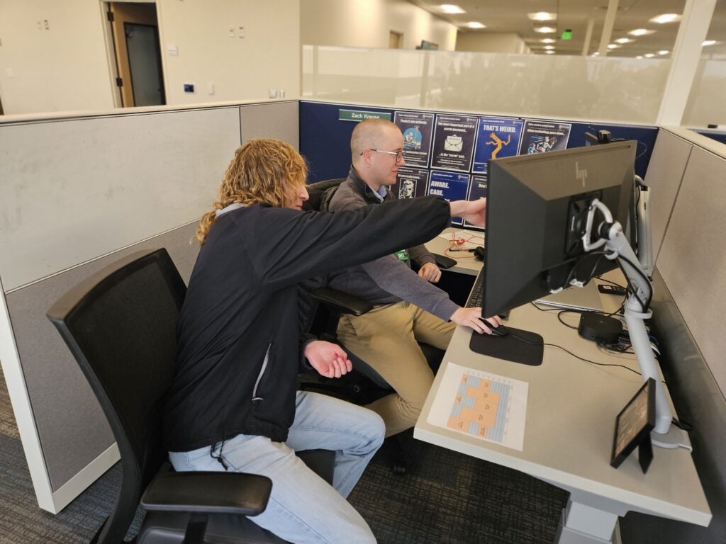 Flor Perez and an intern are looking at a computer