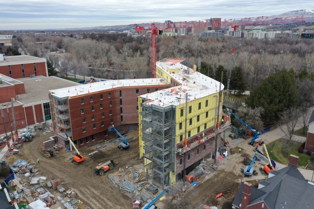 An aerial view of a consecration site with a crane in the background