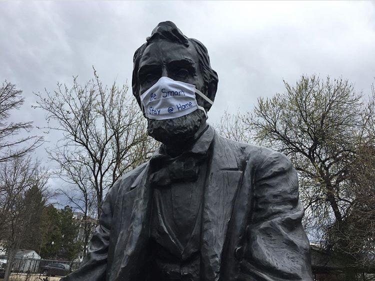 Lincoln Statue wearing face mask that says Be Smart Stay at Home