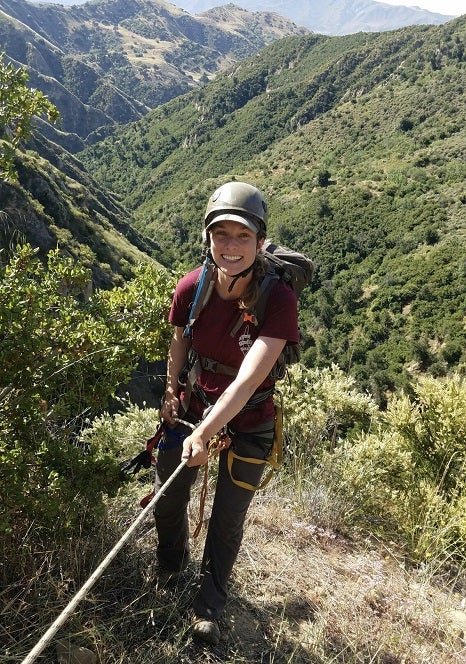 Erin Arnold with climbing gear at the start of a rappel in California wilderness