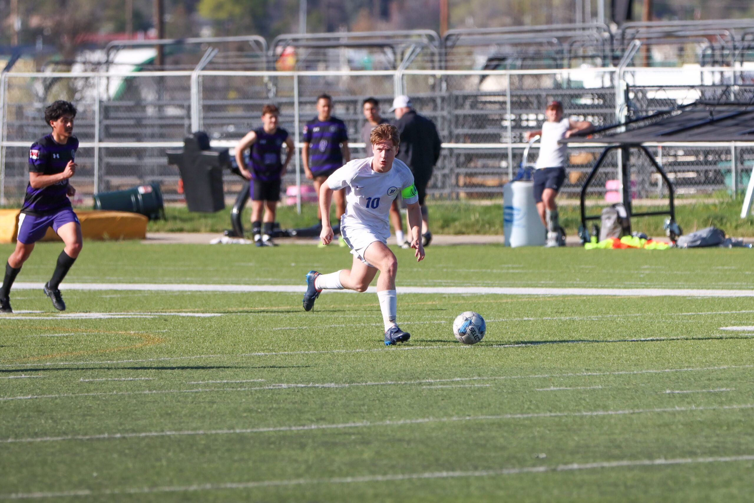 Student playing soccer at a men's soccer club game