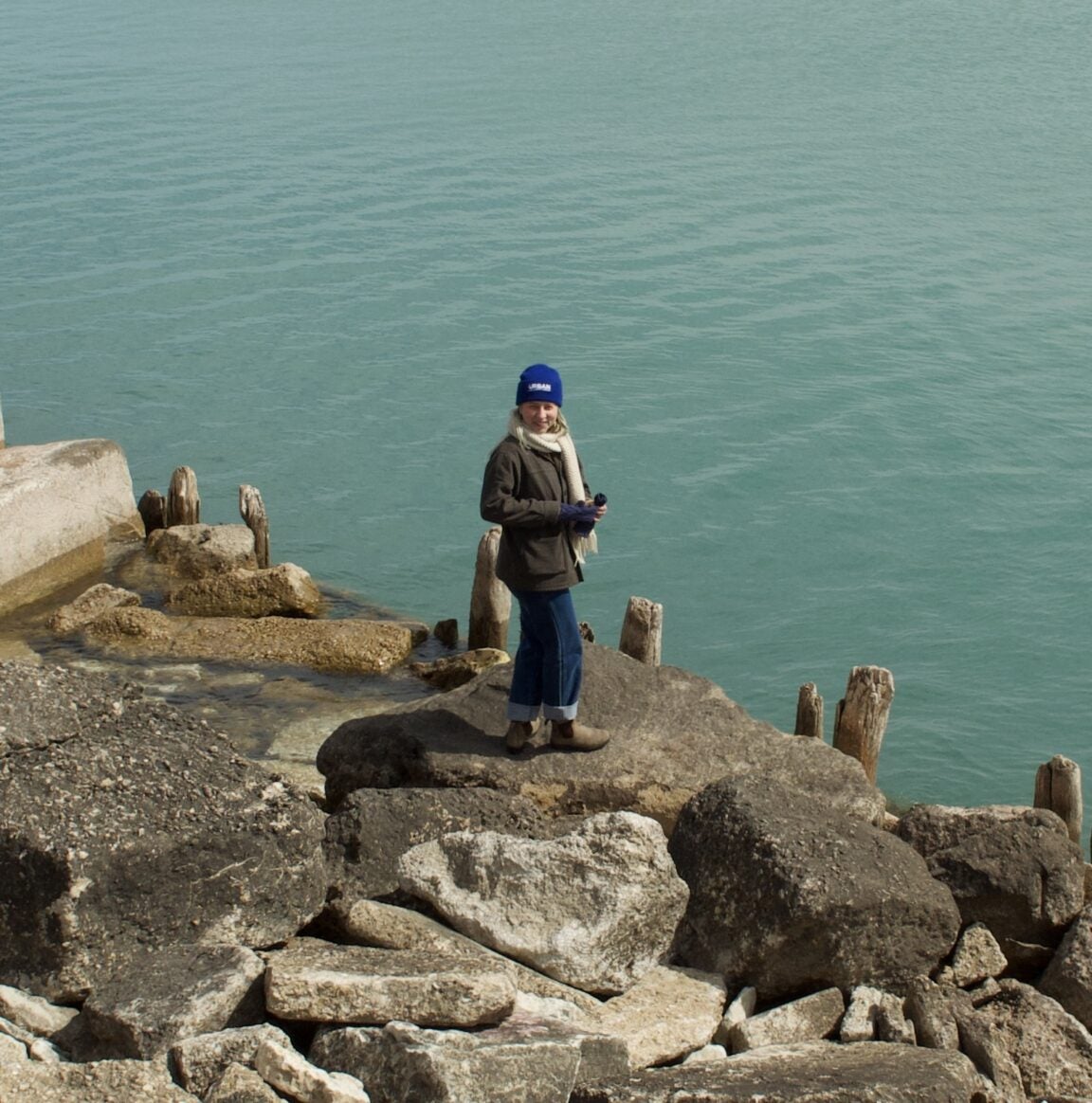 Photo of Patience standing on a cliff with a lake in background