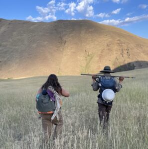 two students walk through rangelands to conduct carbon sequestration research