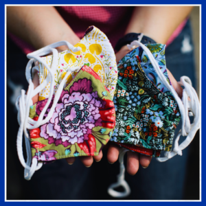 In Cassie Koerner's hands, she holds four beautifully sewn masks with colorful fabrics that she made during COVID 19.