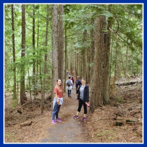 Cassie Koerner smiles with family while hiking in a forested area in Northwest Washington.