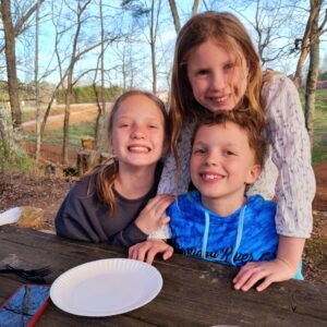 Phoebe, Finn, and Cleo smile at the camera 