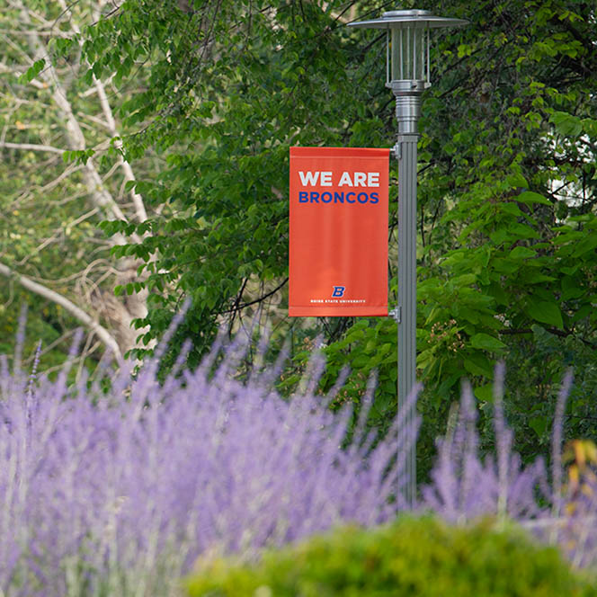 Orange banner with text "WE ARE BRONCOS" hanging in a lamppost