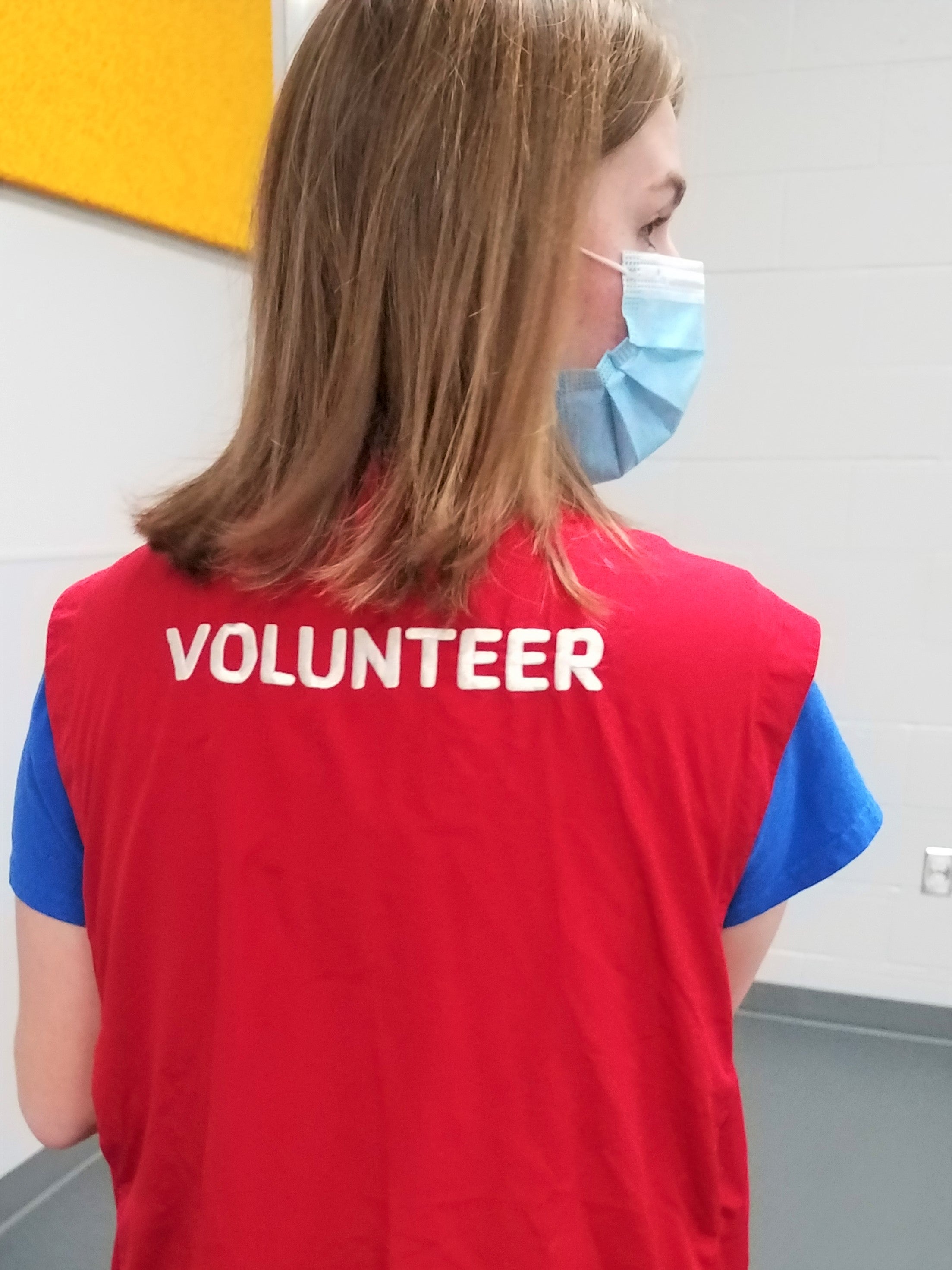 Student wearing a red volunteer vest