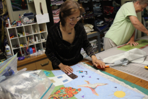 A woman works on a quilt. 