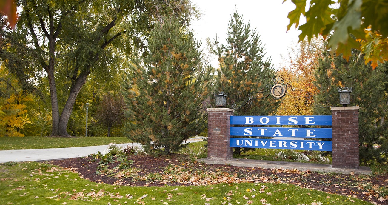 campus scene with Boise State University sign in foreground