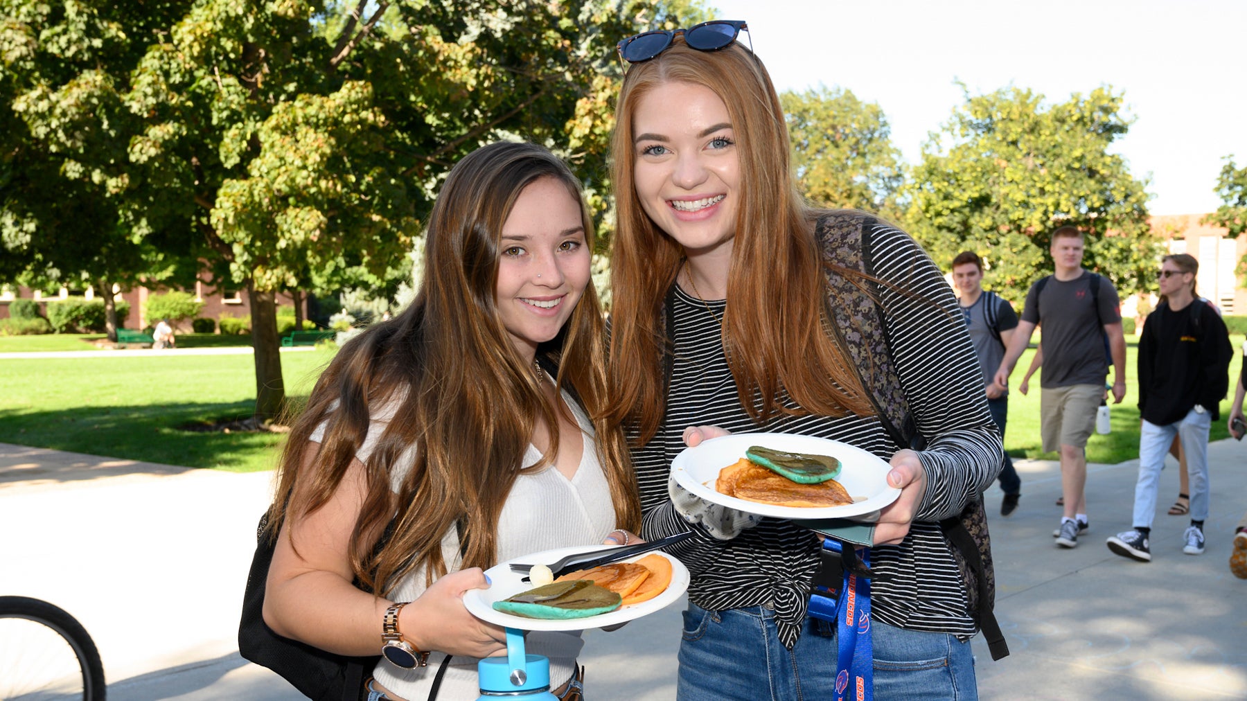Two Boise State students smiling while holding pancakes.