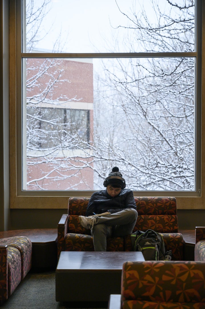 Boise State student studying the Student Union Building near a window with snow outside