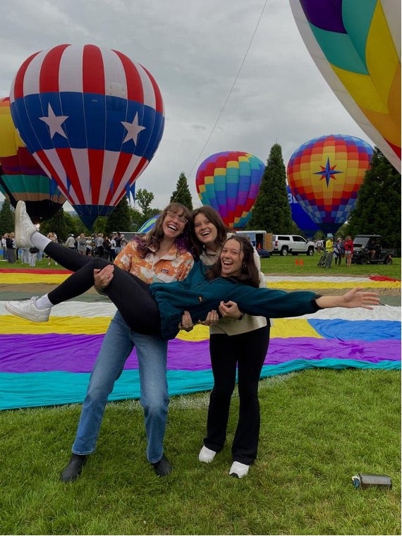 Friends posing in front of hot air balloons