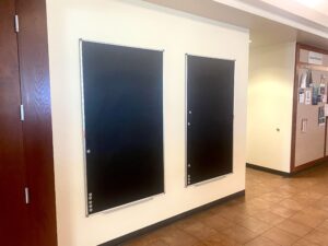 Two blackboards hanging on the Student Union Wall next to the flyer boards in the hallway connecting the Information Desk to Buster's Kitchen.