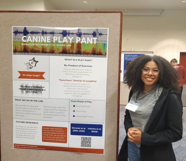 Student standing by their poster at URS 2023