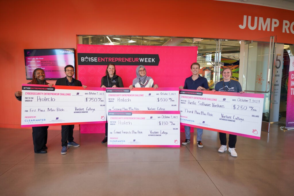 students hold oversized checks at the event